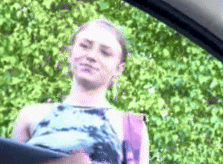 a woman is sitting in the back seat of a car with a backpack .