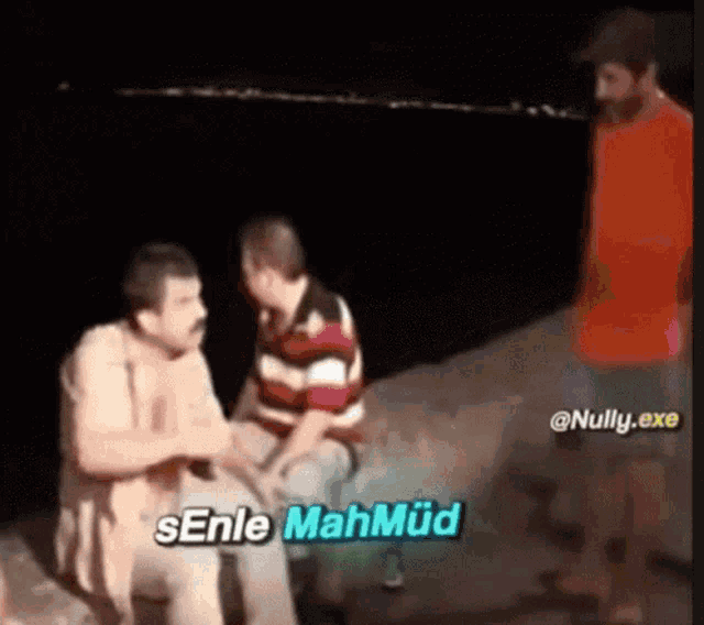 a group of men are sitting on a rock and one of them says senle mahmud ..