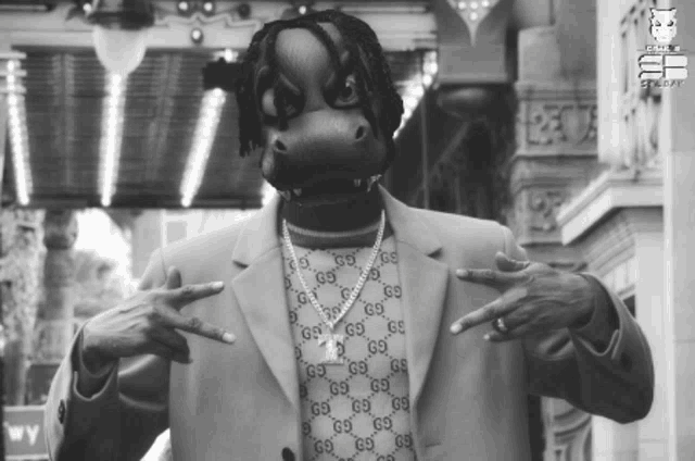 a black and white photo of a man wearing a gucci sweater and jacket