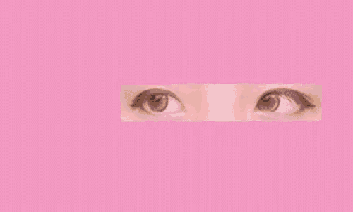a person is holding a piece of paper with a picture of a woman 's eyes on it against a pink background .