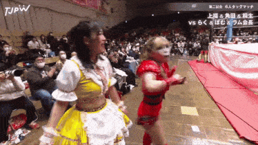 two women wrestling in front of a crowd with tjpw written on the bottom left