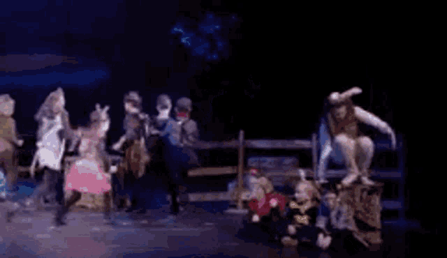 a group of people are dancing on a stage in a musical .