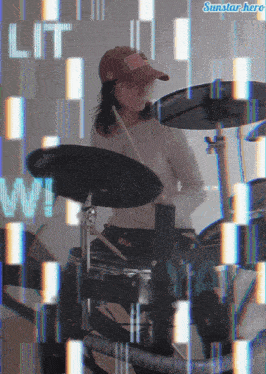 a woman playing drums with a sunstar hero logo above her