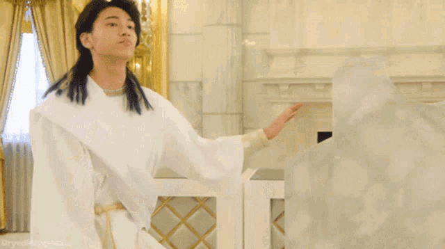 a man in a white robe is dancing in a room with the words dryallpigs.com below him