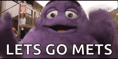 a purple monster is standing in front of a building with the words `` lets go mets '' written below it .