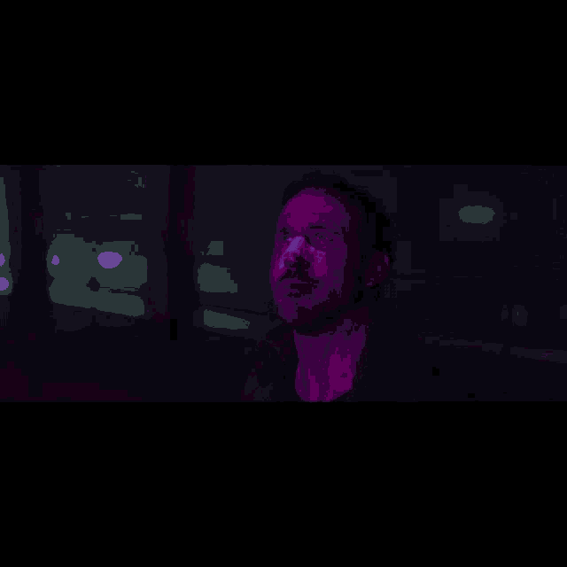 a woman with blue hair stands in a dark room