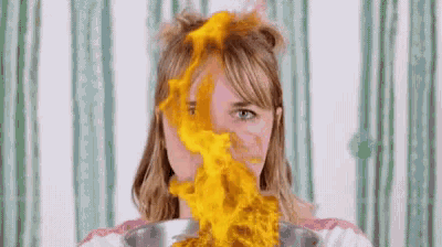 a woman is holding a bowl of food with fire coming out of it .