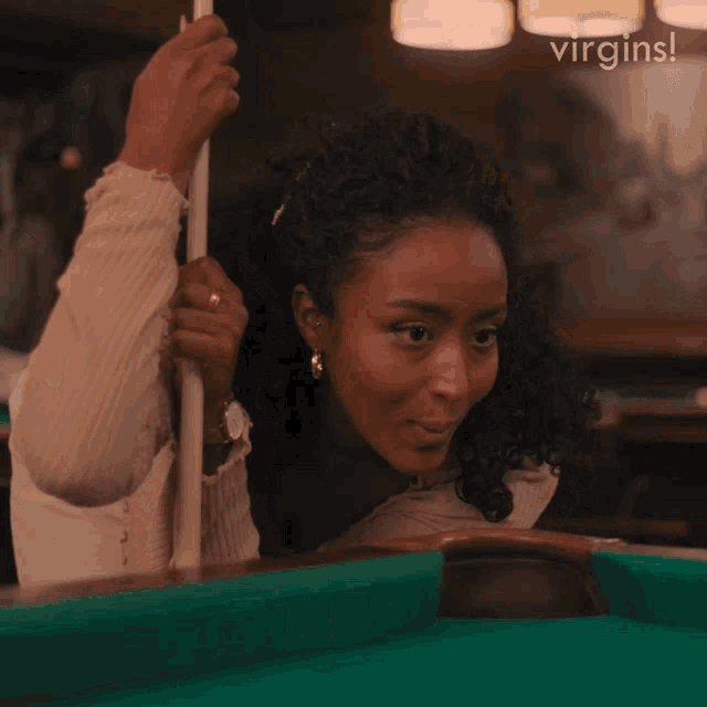 a woman is holding a pool cue and smiling with the words yes behind her