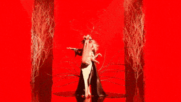 a woman with long red nails is holding a skull