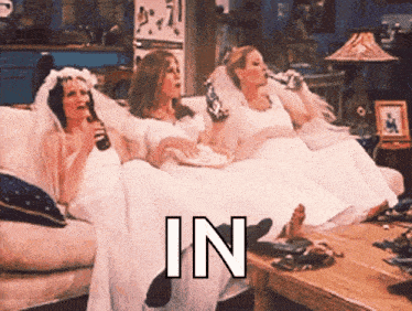 three women in wedding dresses are sitting on a couch with the word " in " on the bottom