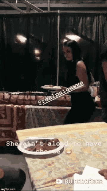 a woman standing next to a table with a plate of food on it