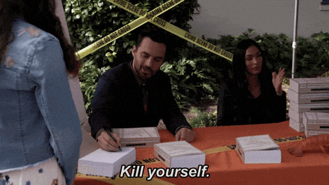 a man signing books at a table with the words kill yourself written on the table cloth