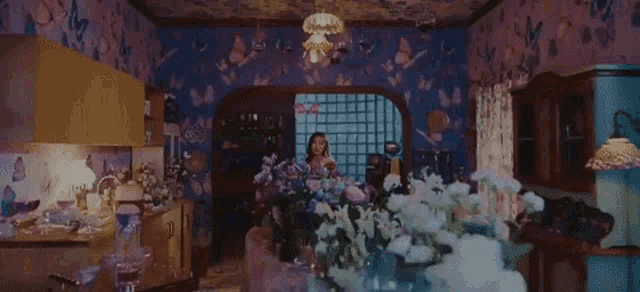 a woman in a plaid shirt is holding flowers in a room .