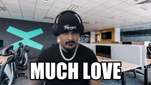 a man wearing headphones and a beanie with the words much love on it