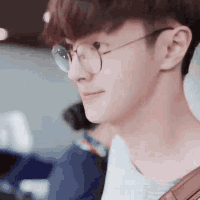 a close up of a young man wearing glasses and a backpack .
