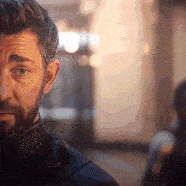 a man with a beard looks at the camera