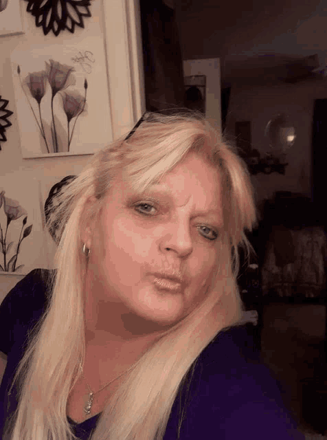 a woman with blonde hair and blue eyes is taking a picture