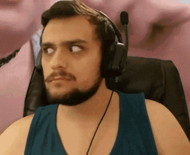 a man with a beard wearing headphones is sitting in a chair .