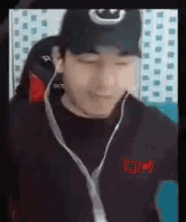 a man wearing a hat and headphones is smiling while looking at the camera .