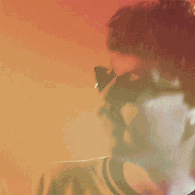 a blurry photo of a man wearing sunglasses and a striped shirt