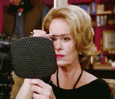 a woman is looking at herself in a mirror while wearing glasses