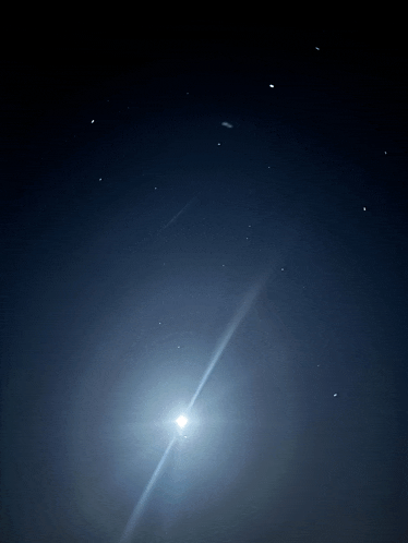 the moon is shining brightly in the night sky with many stars
