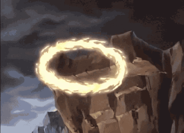 a circle of fire is coming out of a hole in a rocky cliff