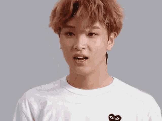 a close up of a young man with red hair wearing a white shirt and a headband .