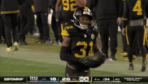 a football player with the number 31 on his jersey is holding a football