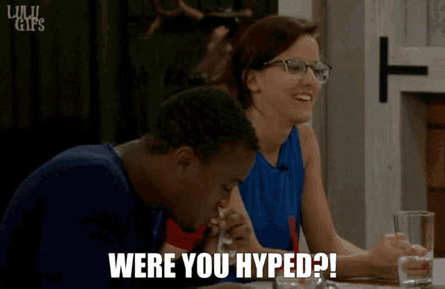 a man and a woman are sitting at a table with the words were you hyped