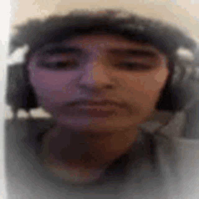 a blurry picture of a person wearing headphones and a hat .