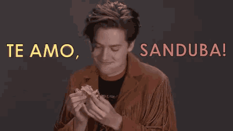 a man in a fringed jacket is holding a piece of food and says te amo sanduba