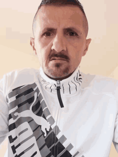 a man is wearing a white puma jacket
