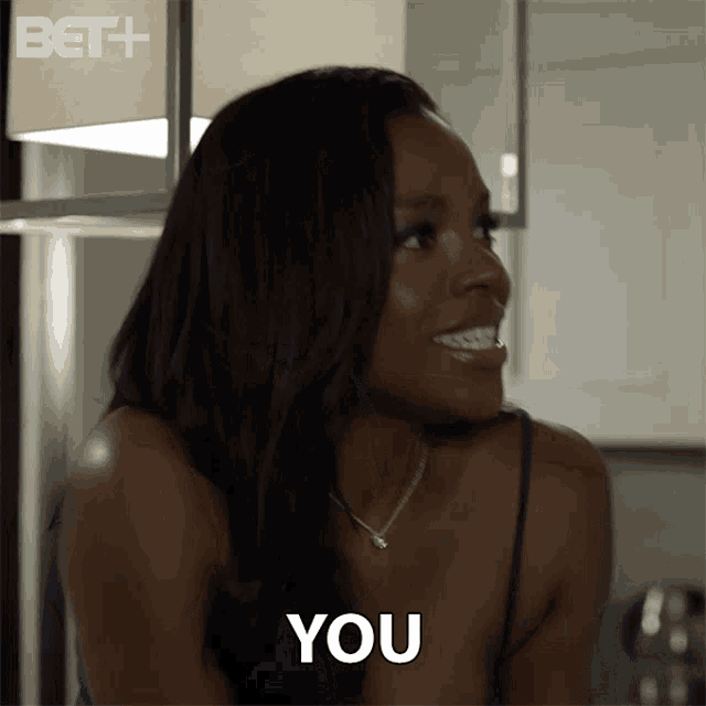 a woman is smiling and says " you " in front of her