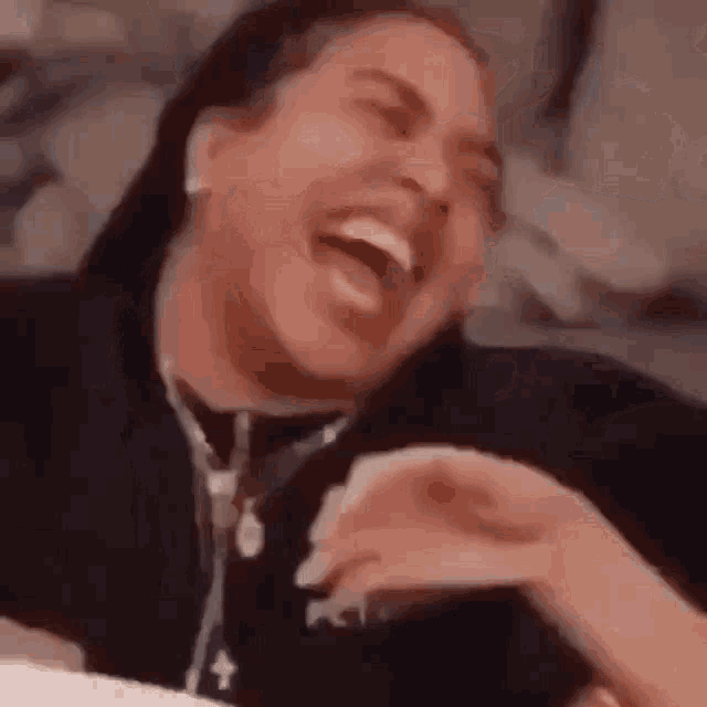 a woman is laughing while laying on a bed .