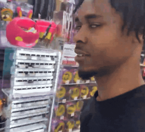 a man in a black shirt is standing in front of a store shelf with a sign that says pepsi