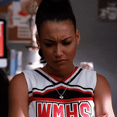 a cheerleader wearing a wmhs uniform looks down