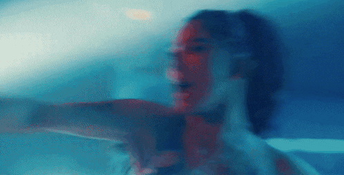 a blurry picture of a woman 's face in a blue light