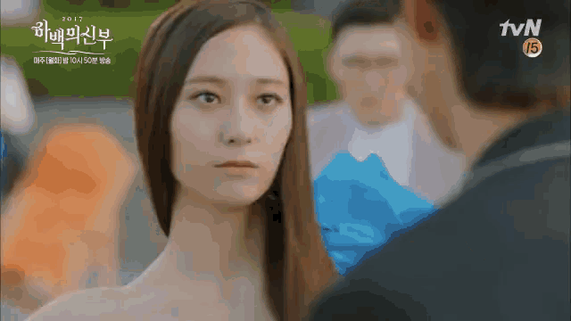 a woman with long hair looks at a man in a tvn ad