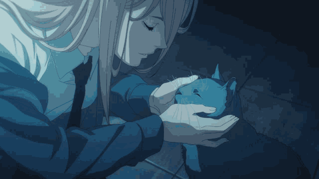 a woman is holding a blue cat in her hands and the cat is looking at the camera