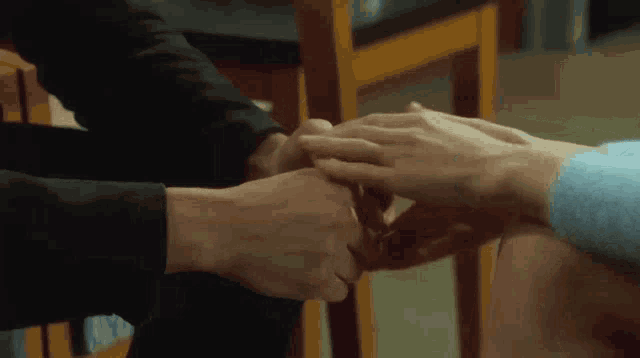 a man and a woman are holding hands while sitting on a chair