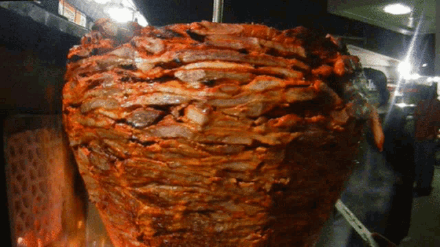 a large piece of meat is being cooked on a grill