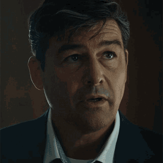 a man in a suit and tie says alright in white letters