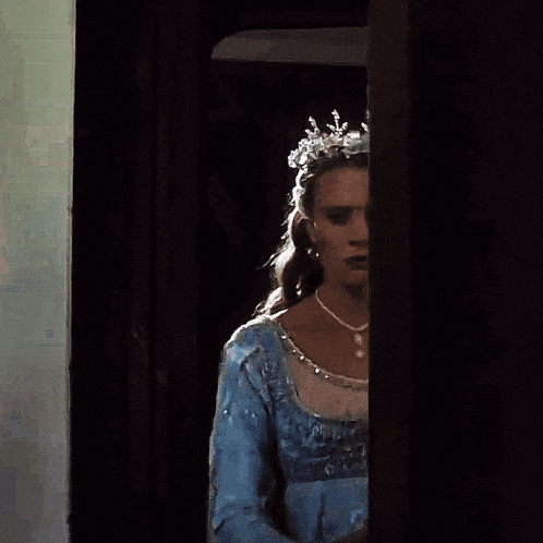 a woman wearing a blue dress and a silver tiara