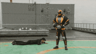 a man in a suit is laying on the ground next to a superhero