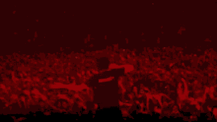 a crowd of people at a concert with a man wearing a black shirt that says ' i love you ' on it