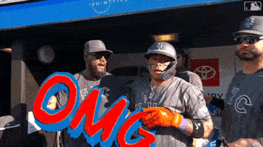 a group of baseball players are standing in front of a sign that says " omg "