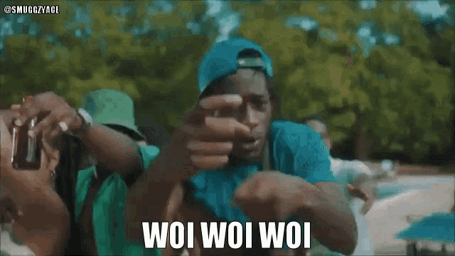 two men are standing next to each other and one of them is pointing at the camera with the words woi woi woi below him