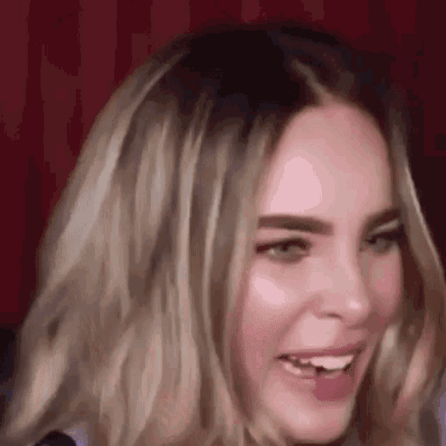 a close up of a woman 's face with her mouth open and a red background .
