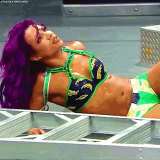 a woman with purple hair is laying on a ladder .